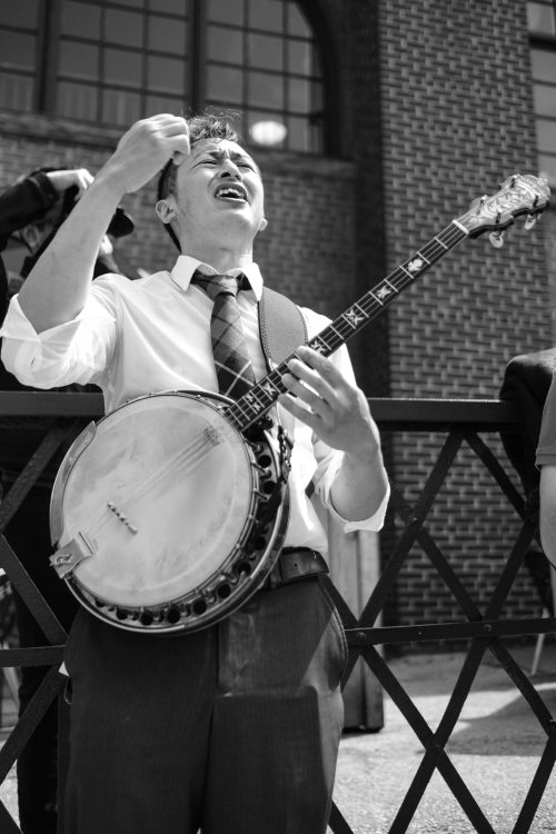 Man sings with passionate expression while playing the banjo.